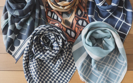 Collage of colorful custom scarves designed with unique patterns on a wooden surface